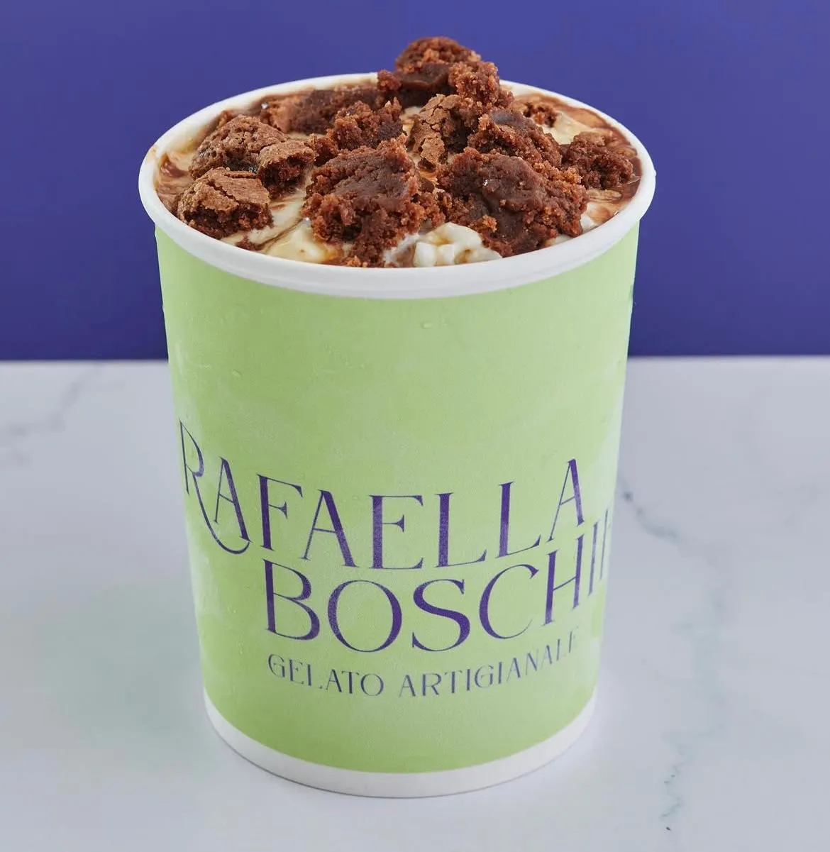Pote de gelato de caramelo salado cubierto con trozos de brownie
